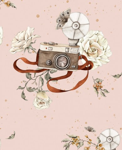 Mussola, una macchina fotografica d'epoca e fiori su uno sfondo rosa